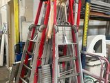 de nombreuses échelles empilées les unes sur les autres dans un garage