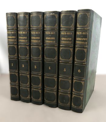 cinq livres noirs sont alignés sur une surface blanche