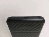 the back of a black cell phone sitting on top of a white table
