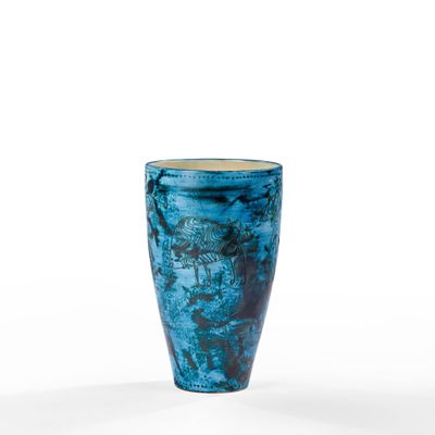 a blue vase that is sitting on a white surface