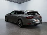 the rear end of a silver car in a white room