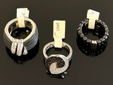 three rings with black and white diamonds on a black surface