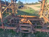 a tractor that is sitting in the grass with a plow attached to it