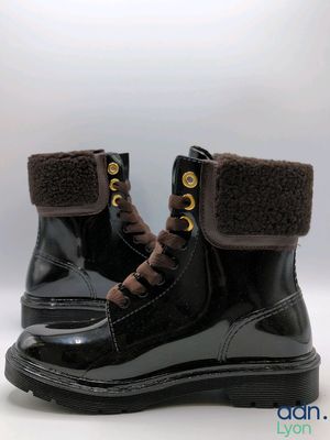 pair of black boots with brown trims on a white background