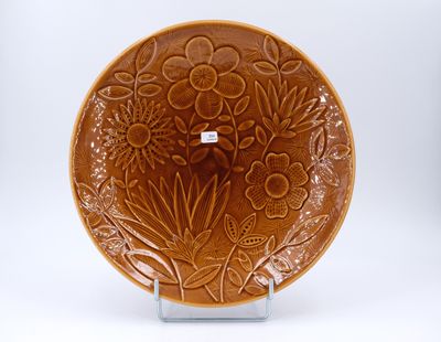 une assiette marron décorée de fleurs et de feuilles