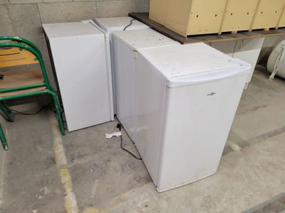 two refrigerators sitting next to each other in a room