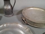 a lot of silver plates and a vase on the table
