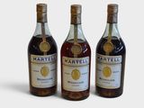 trois bouteilles de vin posées les unes à côté des autres sur une surface blanche