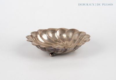 a silver plate with a shell on it on a white surface