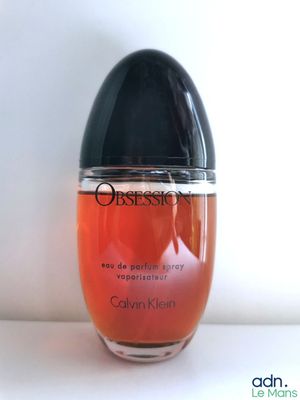 une image montrant un gros plan d'un flacon de parfum posé sur une table
