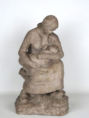 statue représentant une femme tenant un bébé dans ses bras, assise sur un rocher