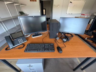 un bureau sur lequel sont posés deux écrans d'ordinateur et un clavier