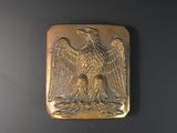 une image représentant une assiette en or ornée d'un aigle