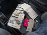 a car dashboard with a bunch of books and magazines on it