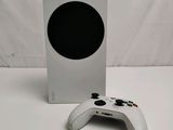 the xbox wireless controller is next to a white box with a black dot