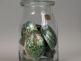 a glass jar filled with glass ornaments on a table