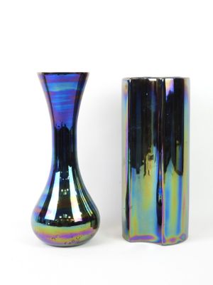 two vases sitting next to each other on a white surface