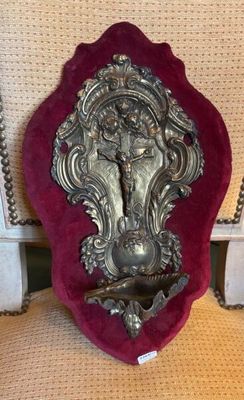 a silver statue on a red velvet cushion on a chair