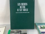 several books on a white table with a green cover and a black and white photo