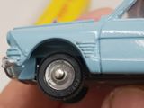a toy car that is being held up in someone ' s hand