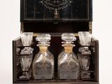 une boîte en bois contenant quatre bouteilles en verre et un miroir