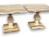 pair of marble tables on pedestals on a white background