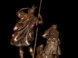 bronze statue of a man and a child with a bird on a black background