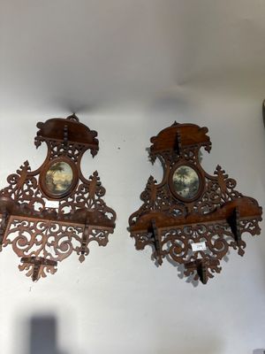 two wooden clocks hanging on the wall next to each other