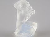 sculpture en verre translucide représentant la tête d'une femme posée sur un plateau
