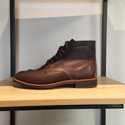 des bottes en cuir marron posées sur une étagère dans un magasin de chaussures