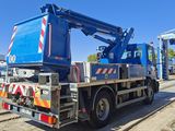 a blue crane that is sitting on the back of a truck