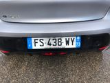 the rear end of a silver car with a license plate on it
