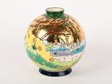 a small vase with a painting on it sitting on a table