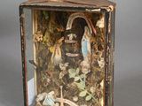 a small box with a doll in it on a table