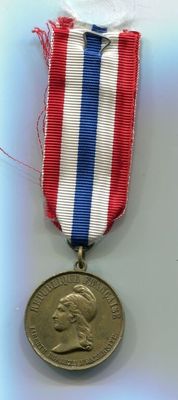 une médaille ornée d'un ruban rouge, blanc et bleu
