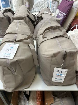 many bags of luggage sitting on a shelf in a store