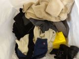 a pile of clothes in a white bag on a bed