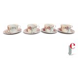 four cups and saucers are lined up on a white surface