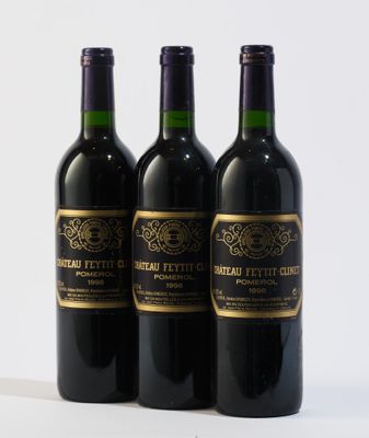 trois bouteilles de vin posées sur une table blanche