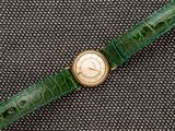 une photo d'une montre-bracelet avec un bracelet en cuir d'alligator vert