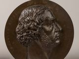 two bronze medallions of a man and a woman