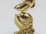 gold pelican figurine sitting on a marble base