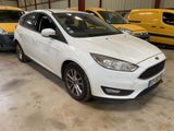 the white ford focus is parked in a garage with other cars