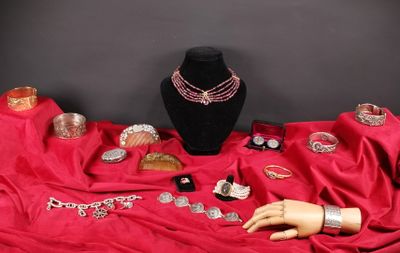 un mannequin et des bijoux posés sur un tissu rouge