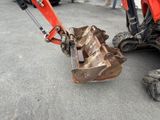 a red excavator that is sitting on the ground