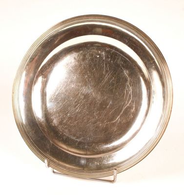 a silver plate on a stand on a white surface