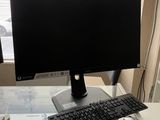 a computer monitor and keyboard on a desk in front of a window