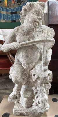 une statue représentant un ours tenant une harpe posée sur une table