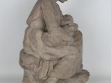 statue of a woman sitting on a rock holding a baby