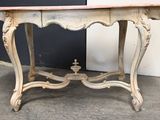a small table with a wooden top on a cement floor